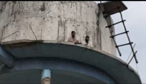 हरदी बाजार में हंगामा: इंसाफ की मांग को लेकर पानी टंकी पर चढ़ा युवक, थाना प्रभारी पर मारपीट और रकम लेने का आरोप।
